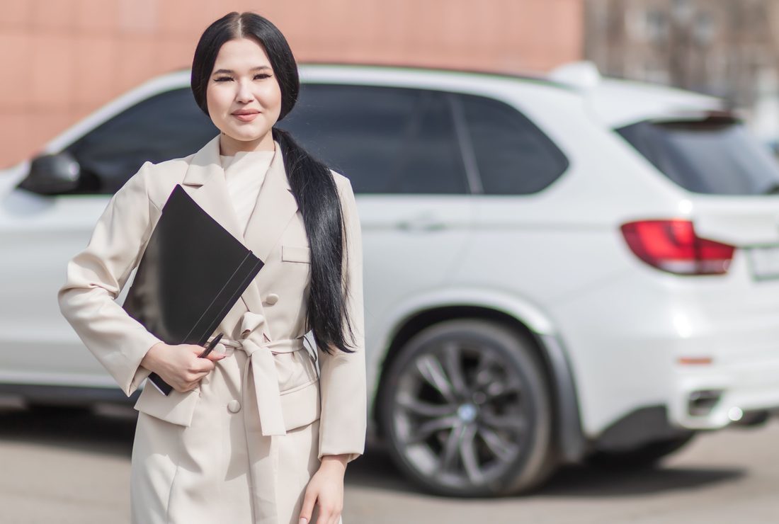 A luxury automotive client advisor beside a client vehicle